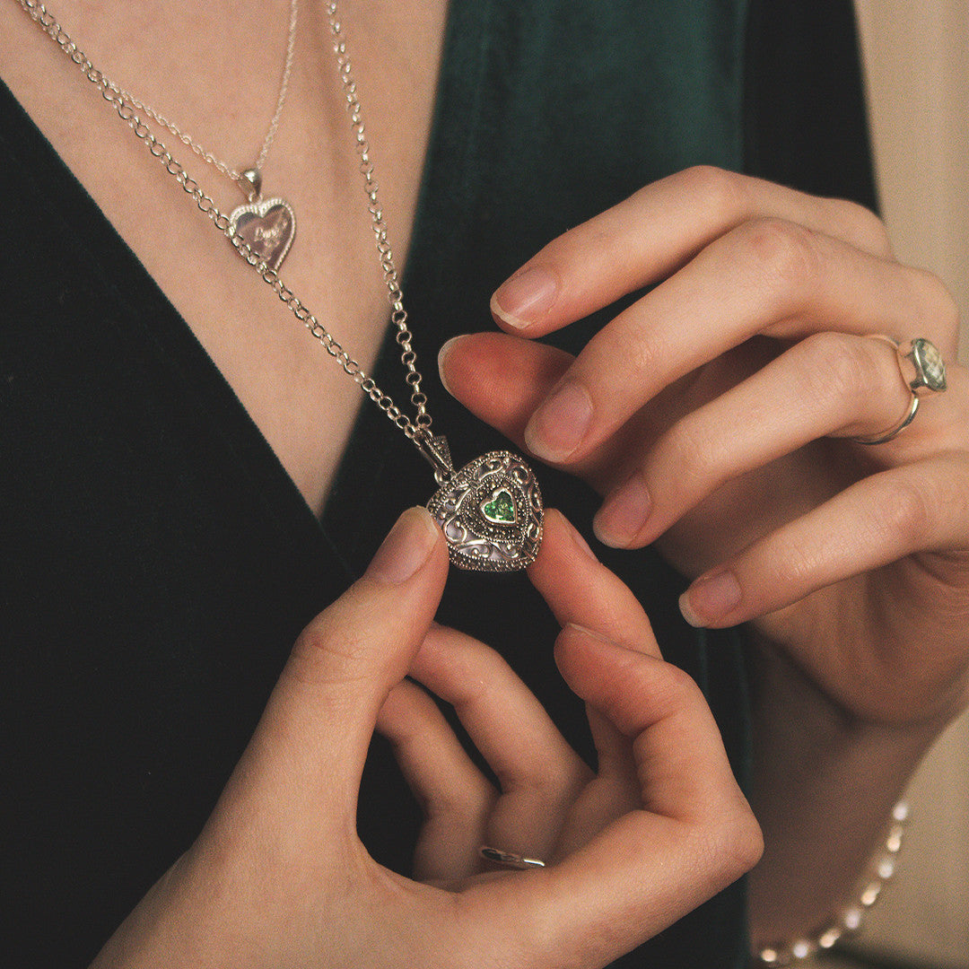 model wearing emerald vintage heart locket in silver