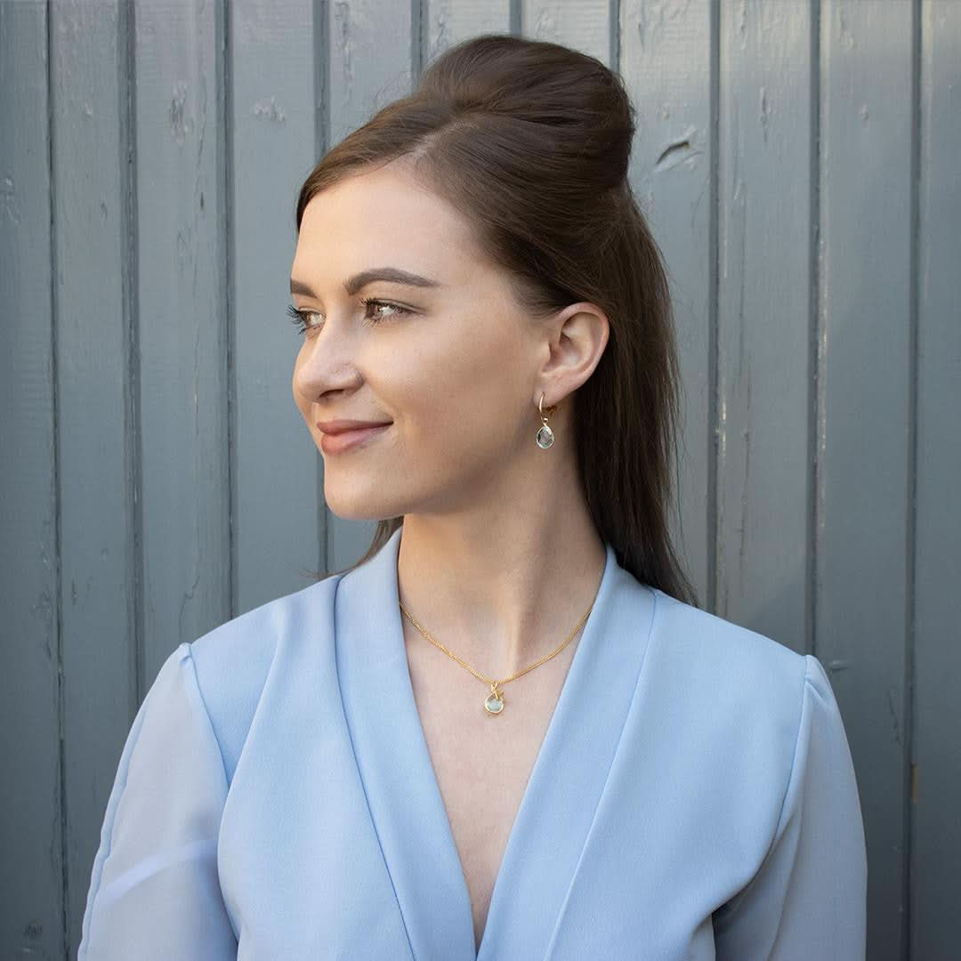 model wearing blue topaz drop hoop earrings in silver