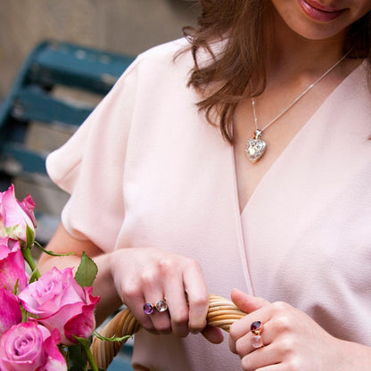 model wearing white gold key locket whilst holding flower basket