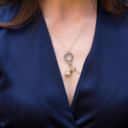 model wearing silver charm carrier pendants with two charms attached