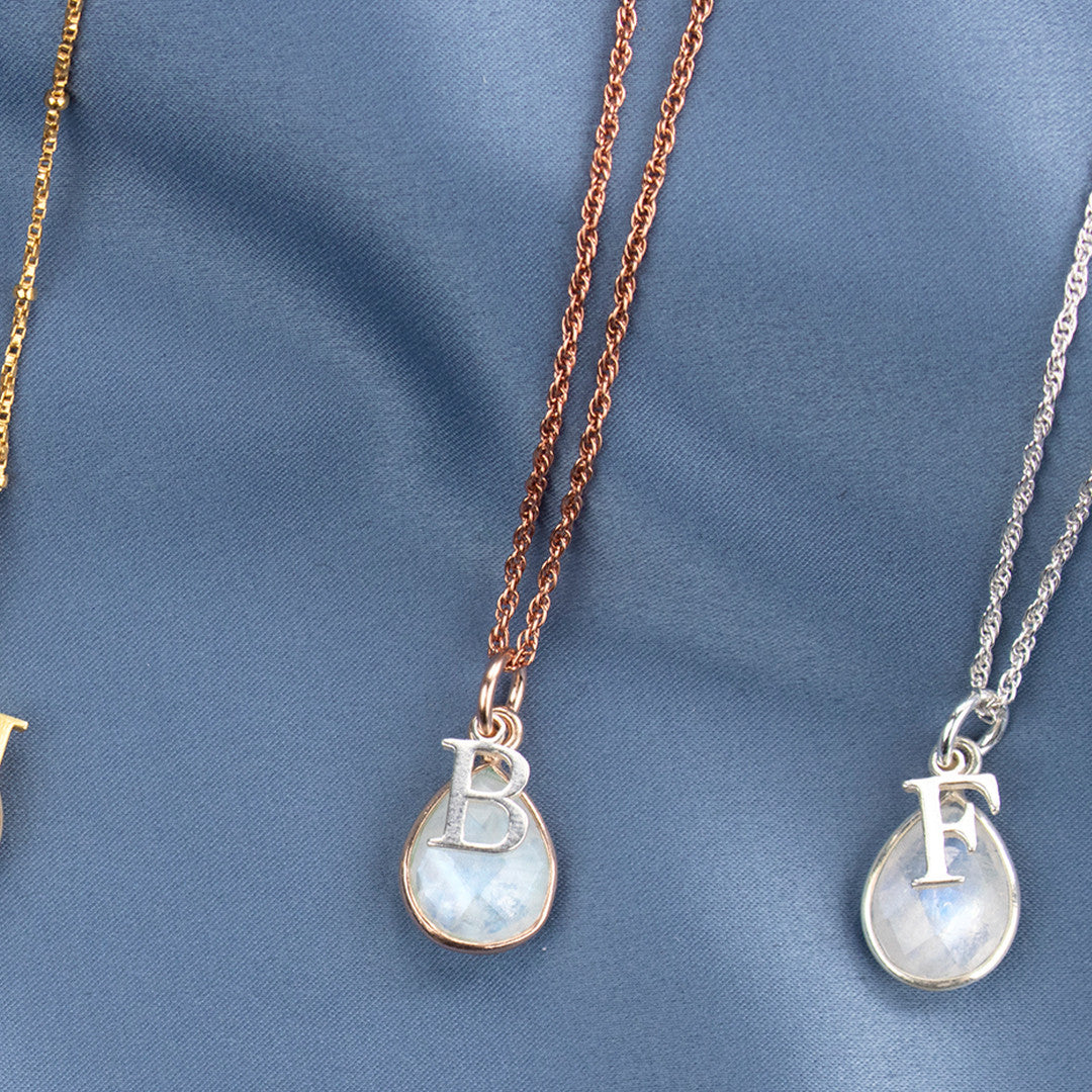 two moonstone charm necklaces with silver initial charms