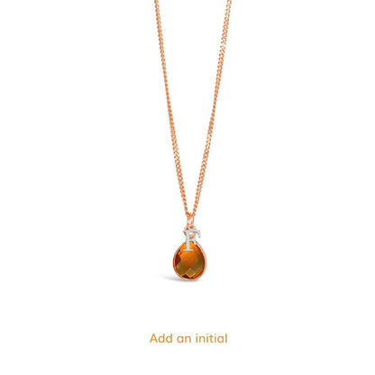 citrine charm necklace in rose gold with silver initial charm on a white background 