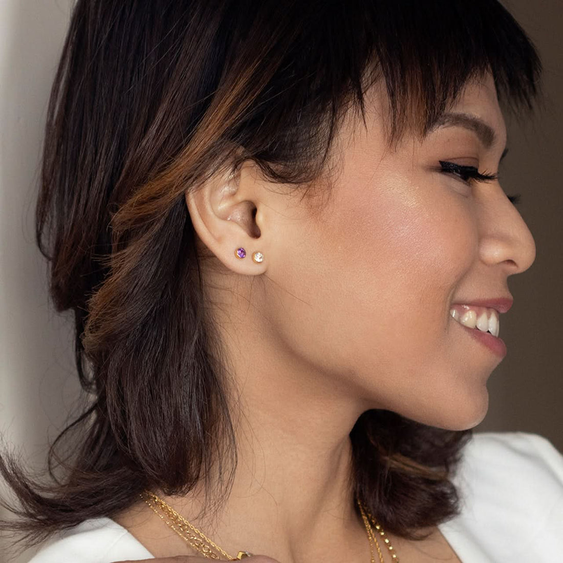 Close up model image wearing white quartz mini stud in rose gold