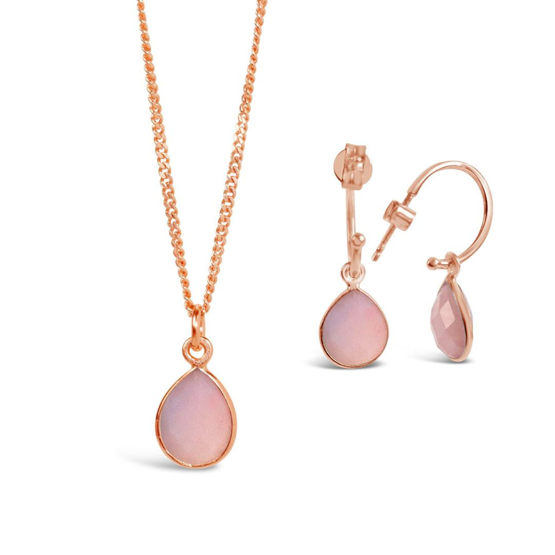 pink opal charm necklace and drop hoop earrings in rose gold on a white background