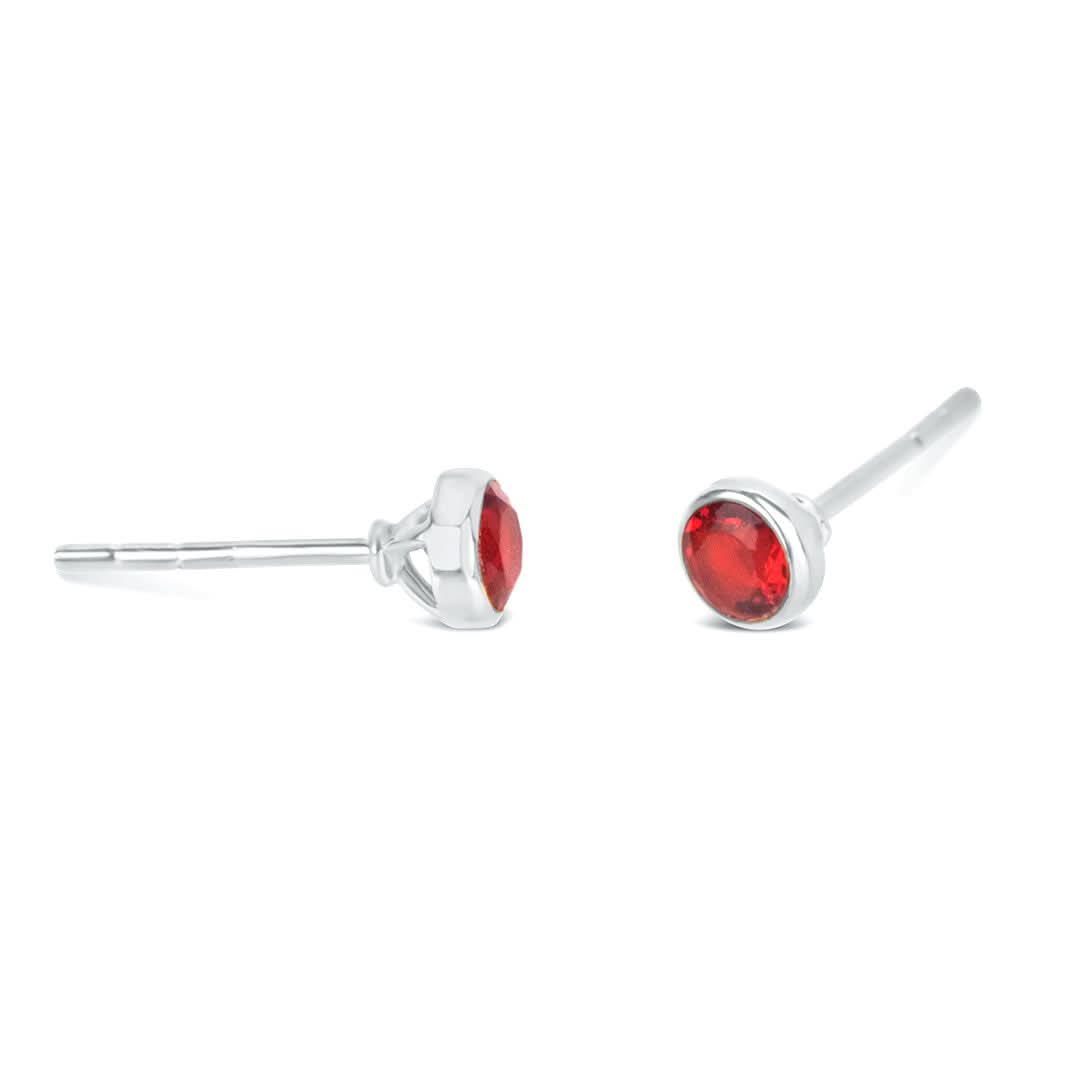 Garnet mini stud earrings in silver facing the side on a white background