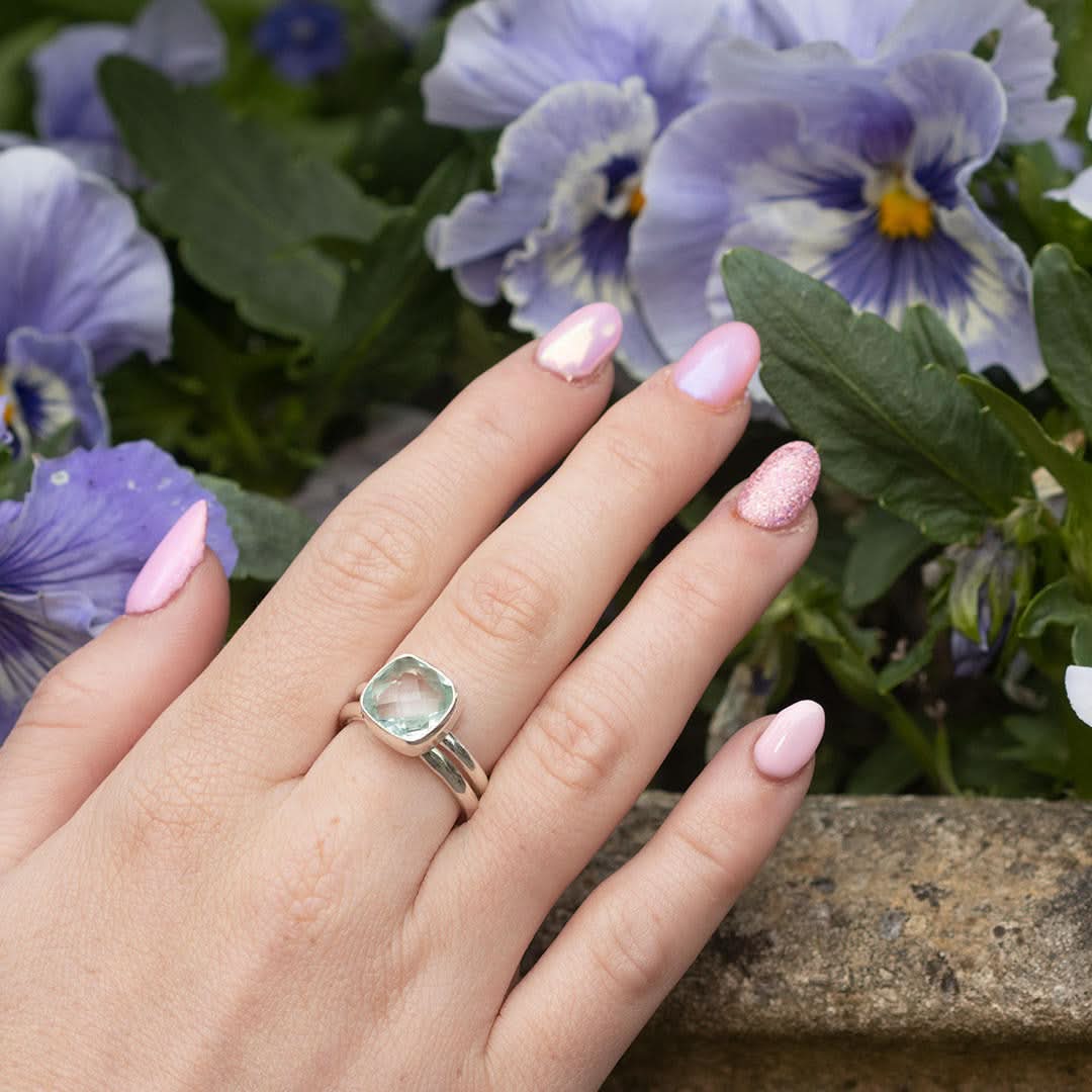 model wearing silver friendship band ring with flowers in the background