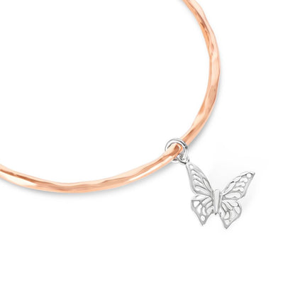 close up of rose gold butterfly bangle on a white background