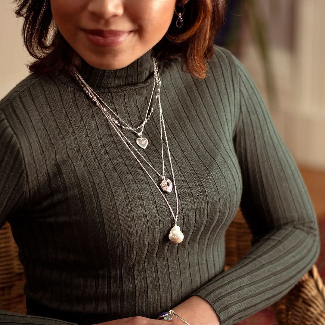 closeup of model wearing silver sapphire heart locket