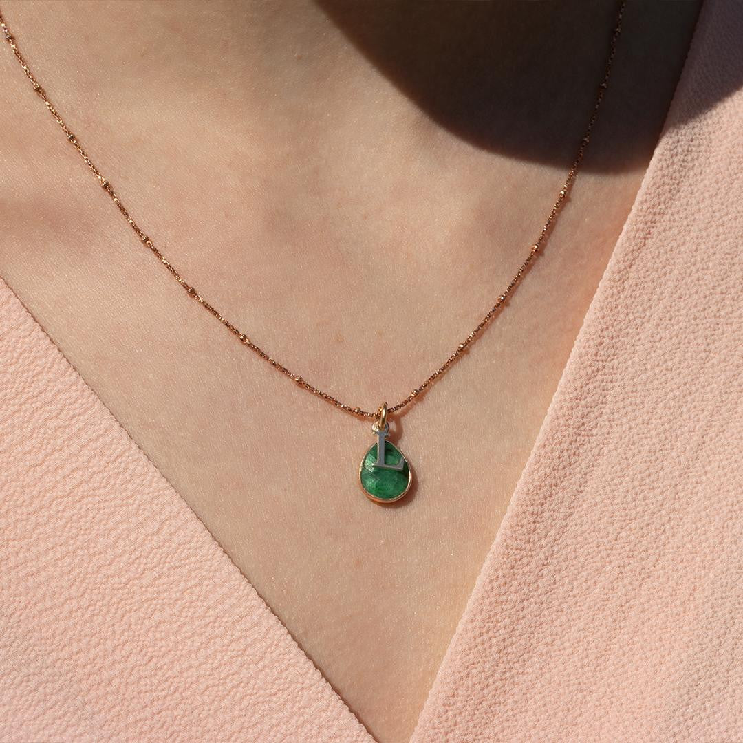 model wearing emerald charm necklace in rose gold with silver initial charm
