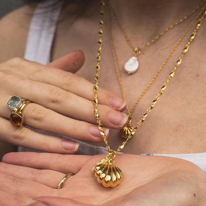 close up of model wearing gold seahorse locket on a twist chain