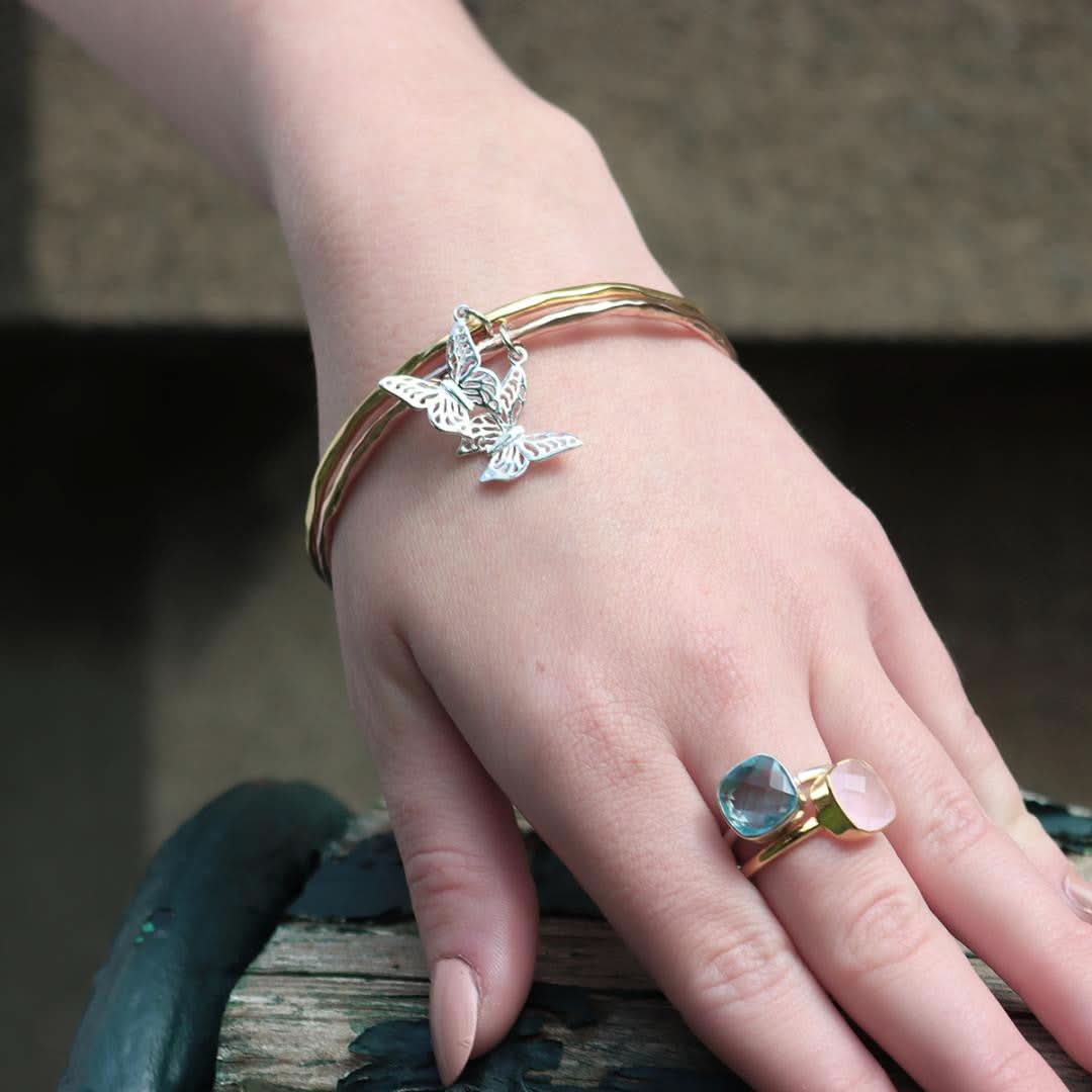 model wearing two butterfly bangles on her wrist