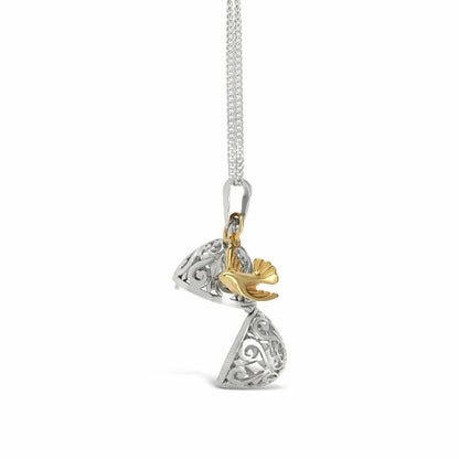 opened bird locket in silver with gold bird charm on white background