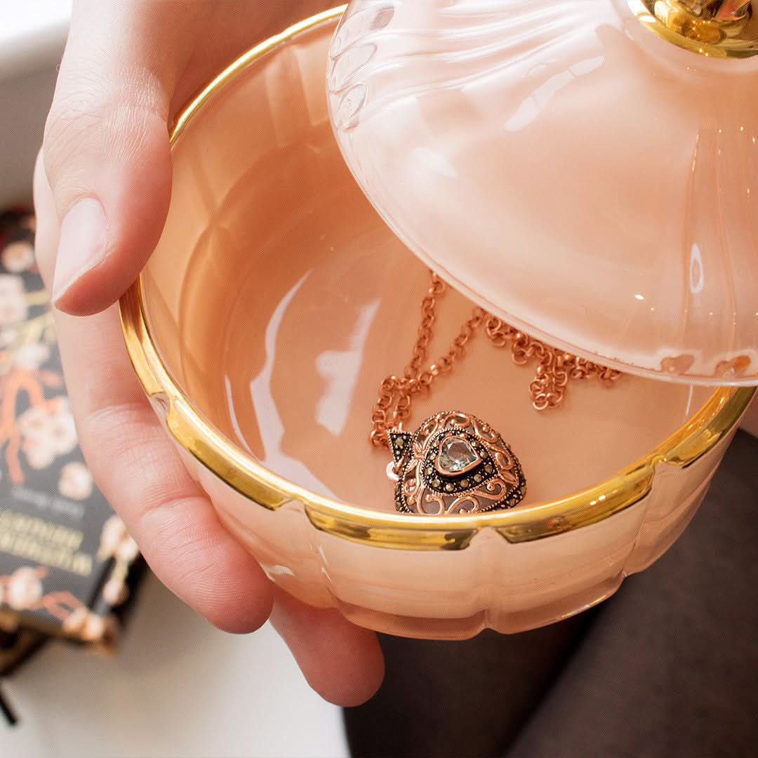 Heart shaped rose gold locket and chain in a jewellery dish