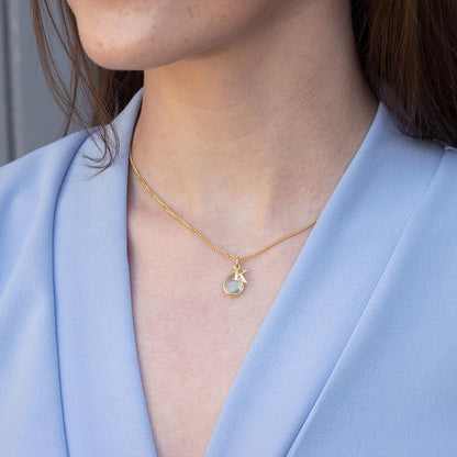 model wearing blue topaz charm necklace with gold initial charm