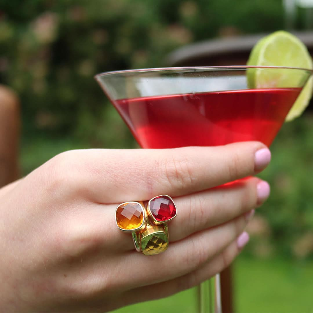 model wearing three cocktail rings in gold with different gemstones 