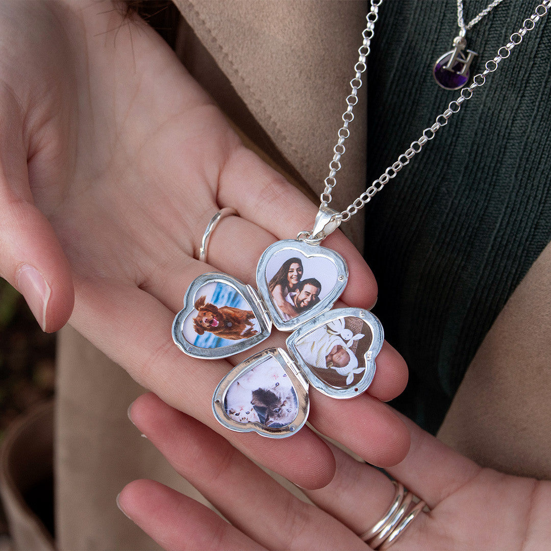 women holding opened four photo heart locket in white gold