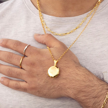 close up of model wearing men's round locket necklace on a gold belcher chain