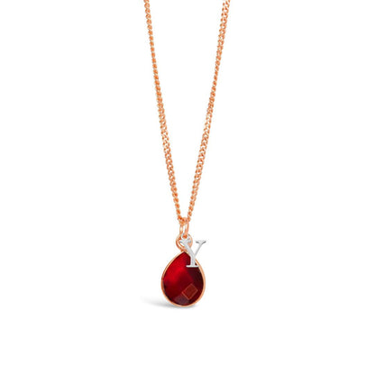 garnet charm necklace in rose gold with silver initial charm on a white background