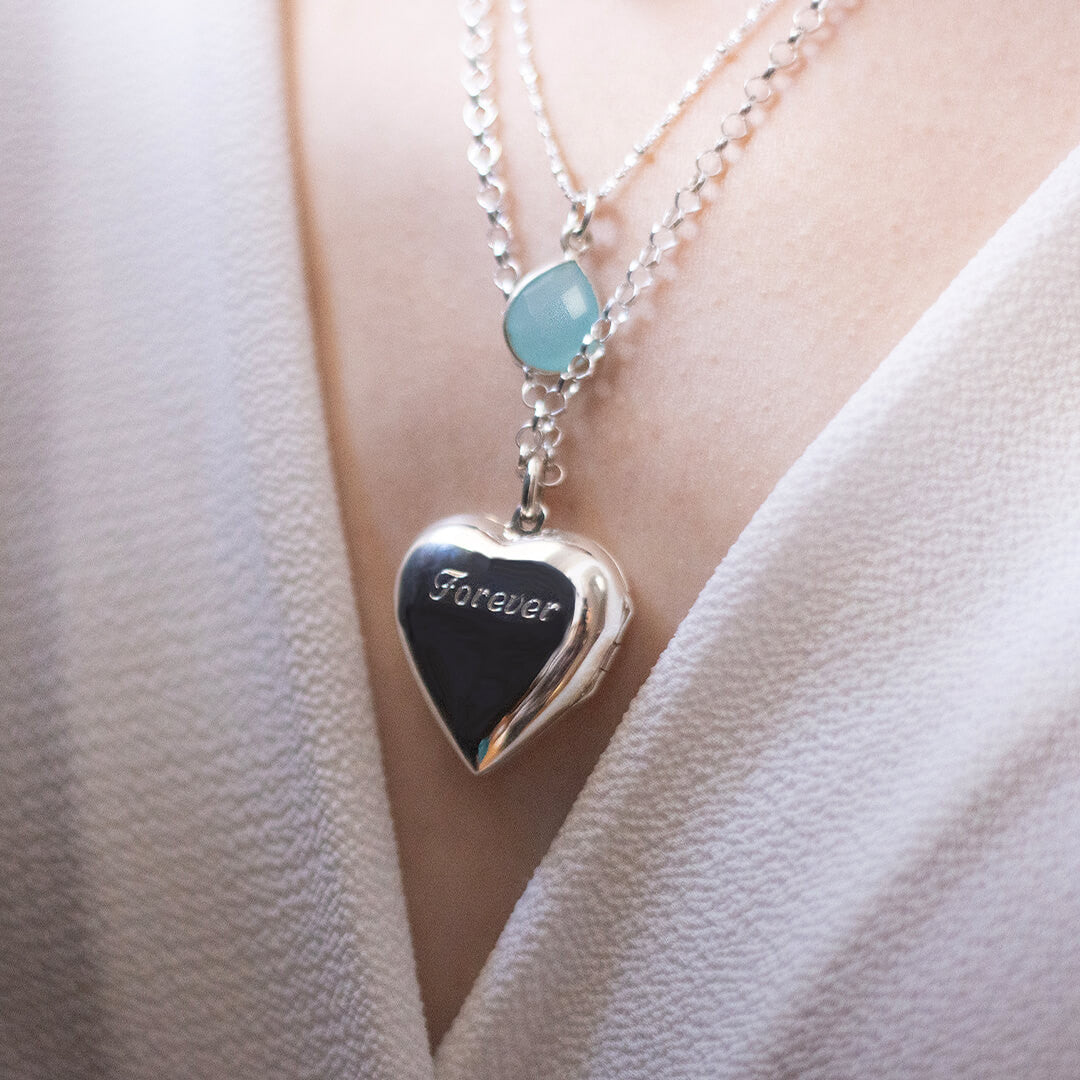 close up of model wearing large two photo heart locket in silver