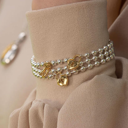 Close up of model wearing sterling silver and gold padlock and key bracelet