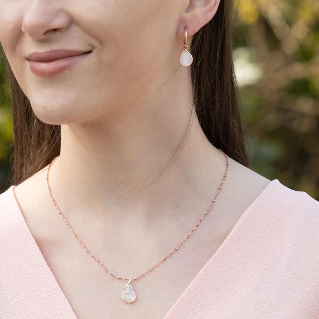 model wearing moonstone drop hoop earrings in rose gold
