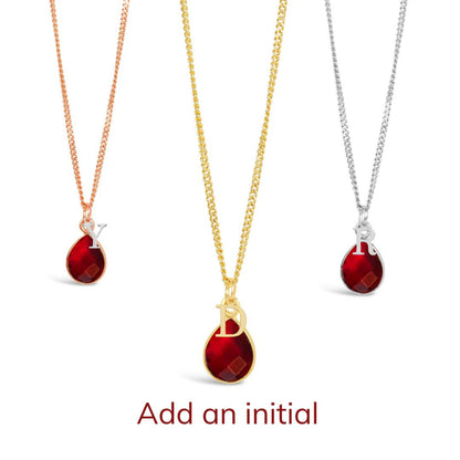 three garnet charm necklaces in silver, gold and rose gold on a white background