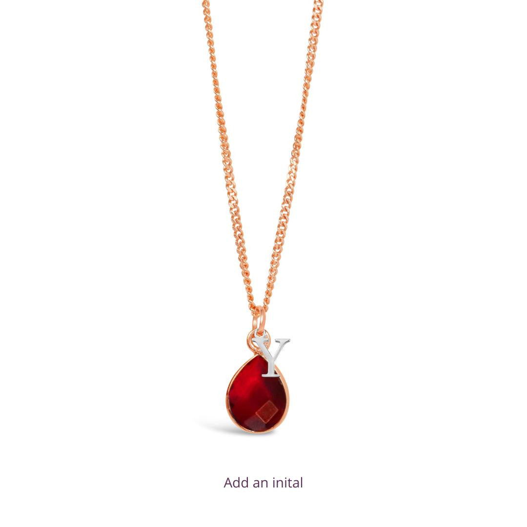 ruby charm necklace in rose gold with silver initial charm  on a white background
