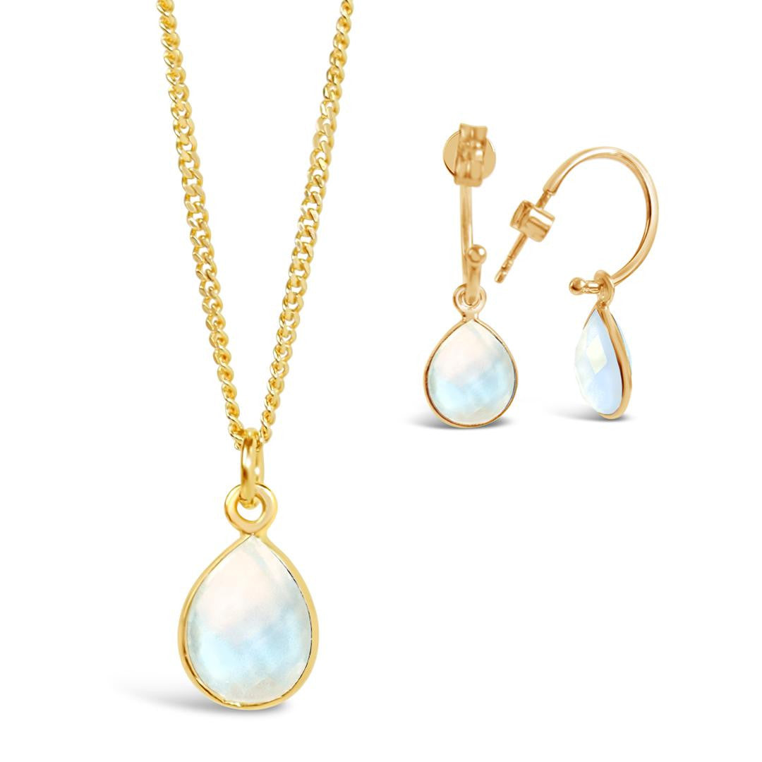 moonstone charm necklace and drop hoop earrings in gold on a white background