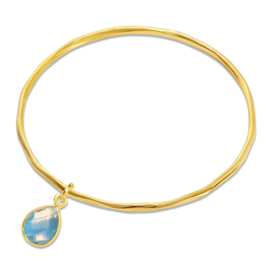 blue topaz charm bangle in gold on a white background