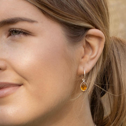 close up of model wearing citrine drop hoop earrings