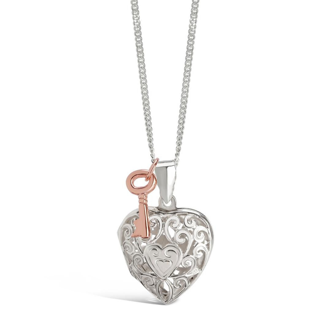white gold key locket with rose gold charm attached on a white background