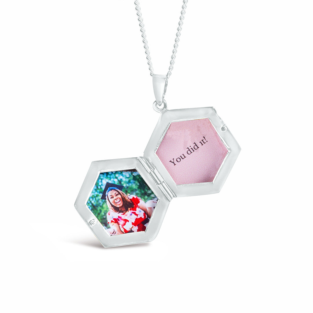 opened hexagon locket in silver with family photos inside