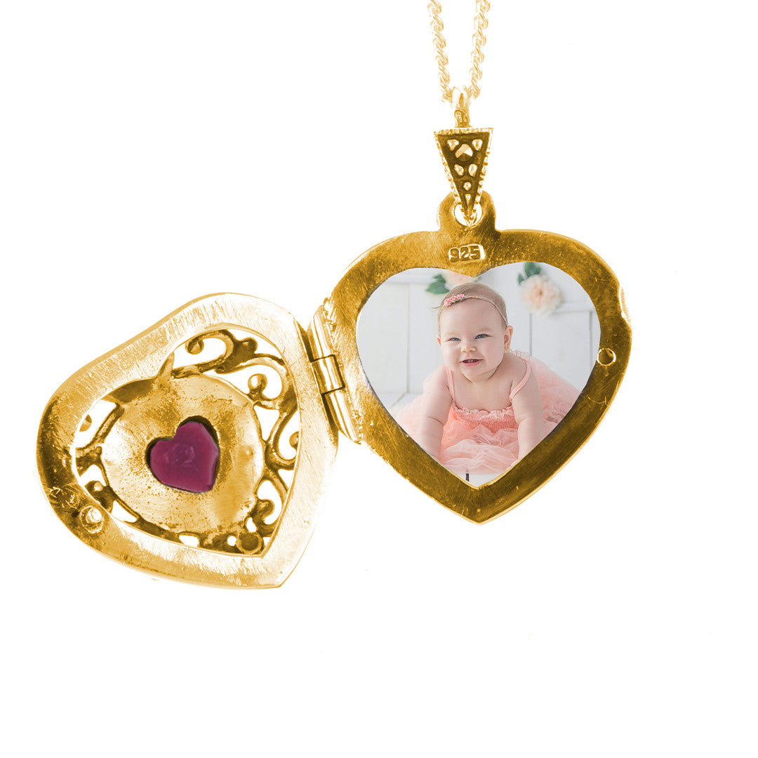 opened ruby vintage heart locket with photo inside on a white background