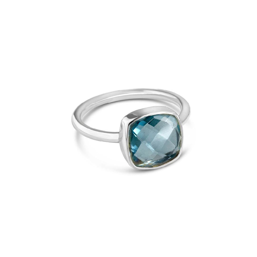 blue topaz cocktail ring in silver on a white background