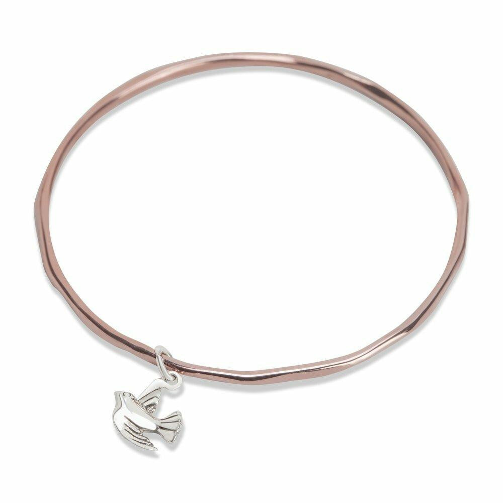 rose gold bangle with silver bird charm on a white background