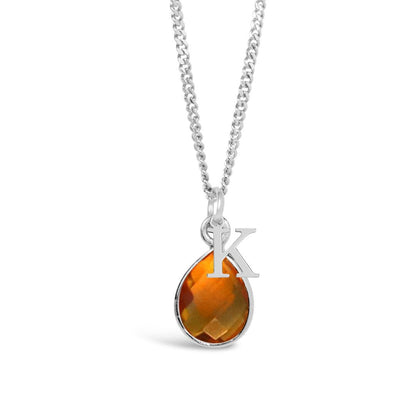 citrine charm necklace with initial charm in silver on a white background