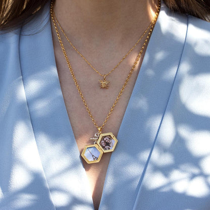 model wearing opened bee locket in gold with photos inside