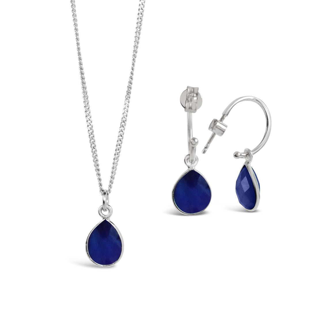 silver sapphire charm necklace and drop hoop earrings on a white background