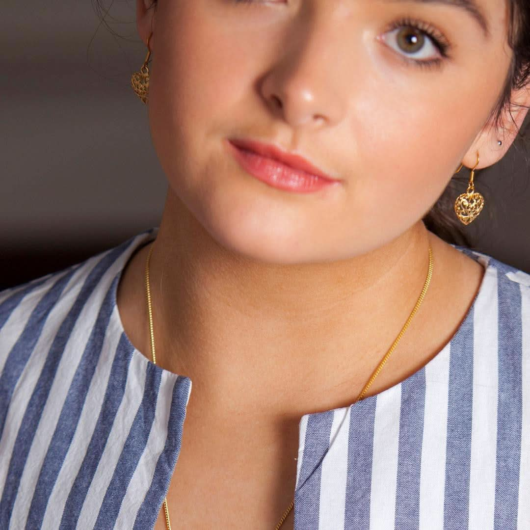 model wearing heart earrings in gold 