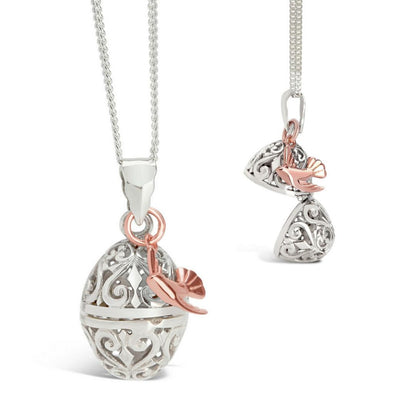 white gold bird locket with rose gold charm attached on a white background