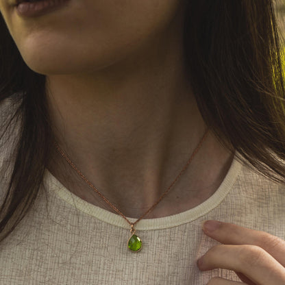 close up of model wearing rope chain in rose gold with peridot gemstone