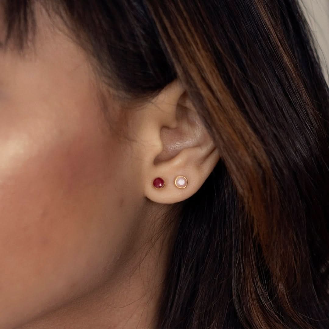 Lily Blanche rose gold moonstone stud earrings and ruby stud earrings on a model stacked together