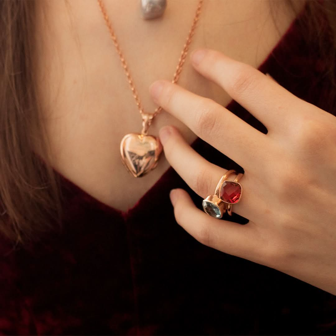 close up of model wearing two cocktail rings each with different gemstones