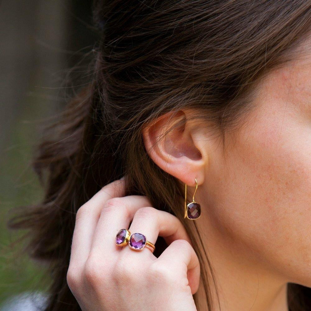 model wearing purple amethyst earrings and matching ring in gold