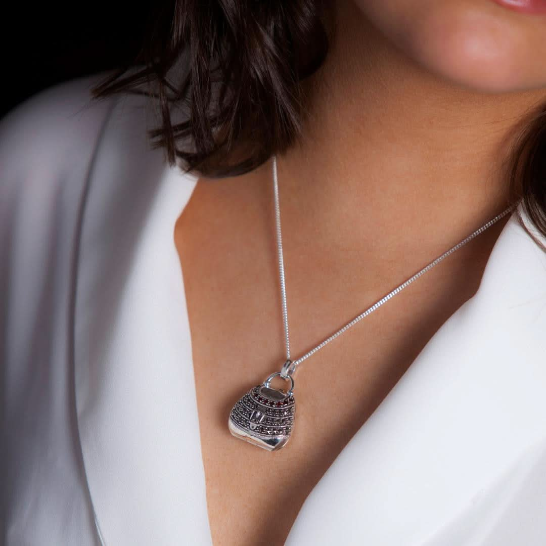 model wearing garnet handbag locket in silver