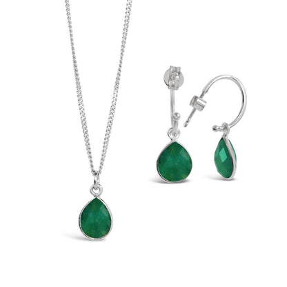 emerald charm necklace and drop hoop earrings on a white background