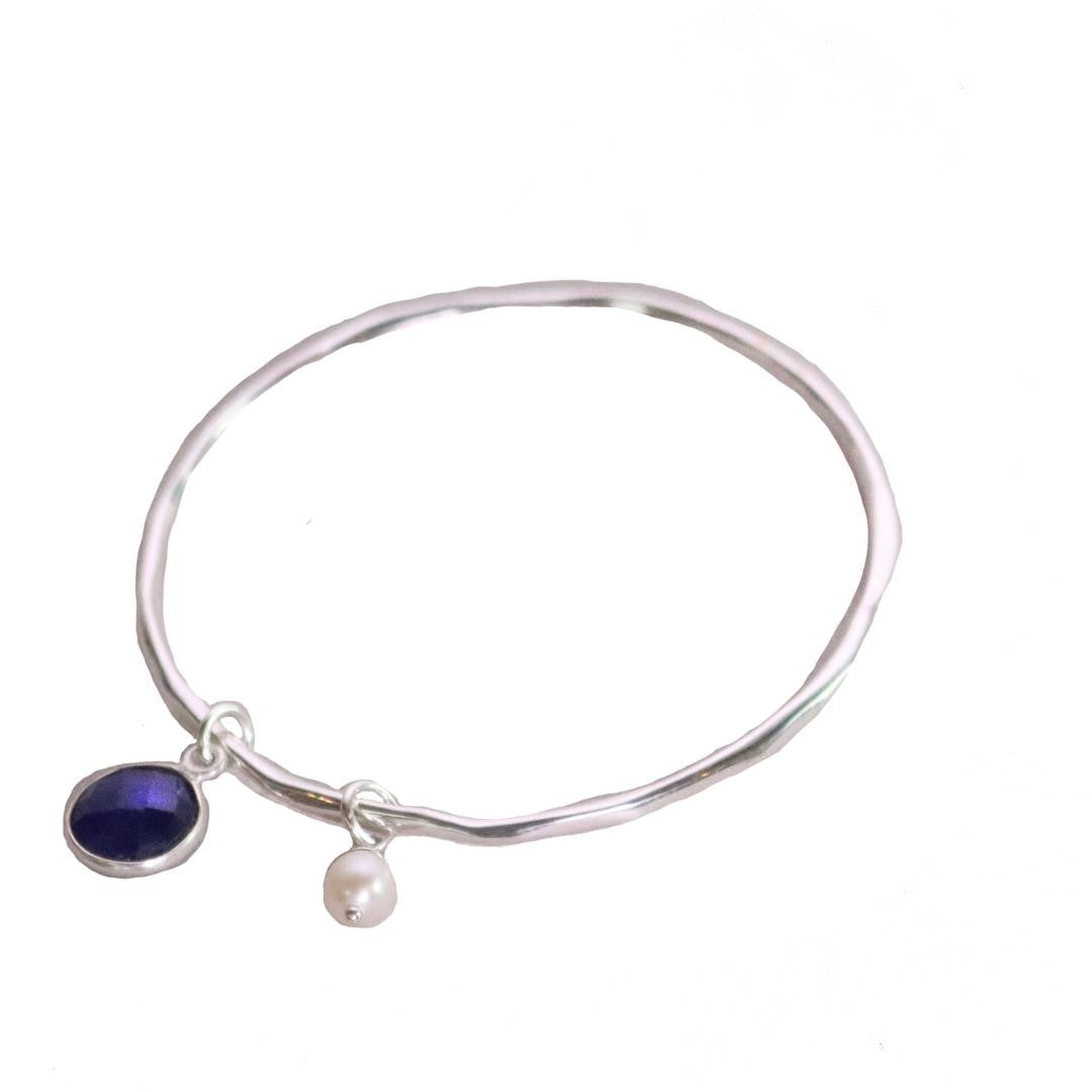 sapphire charm bangle with silver pearl attached 