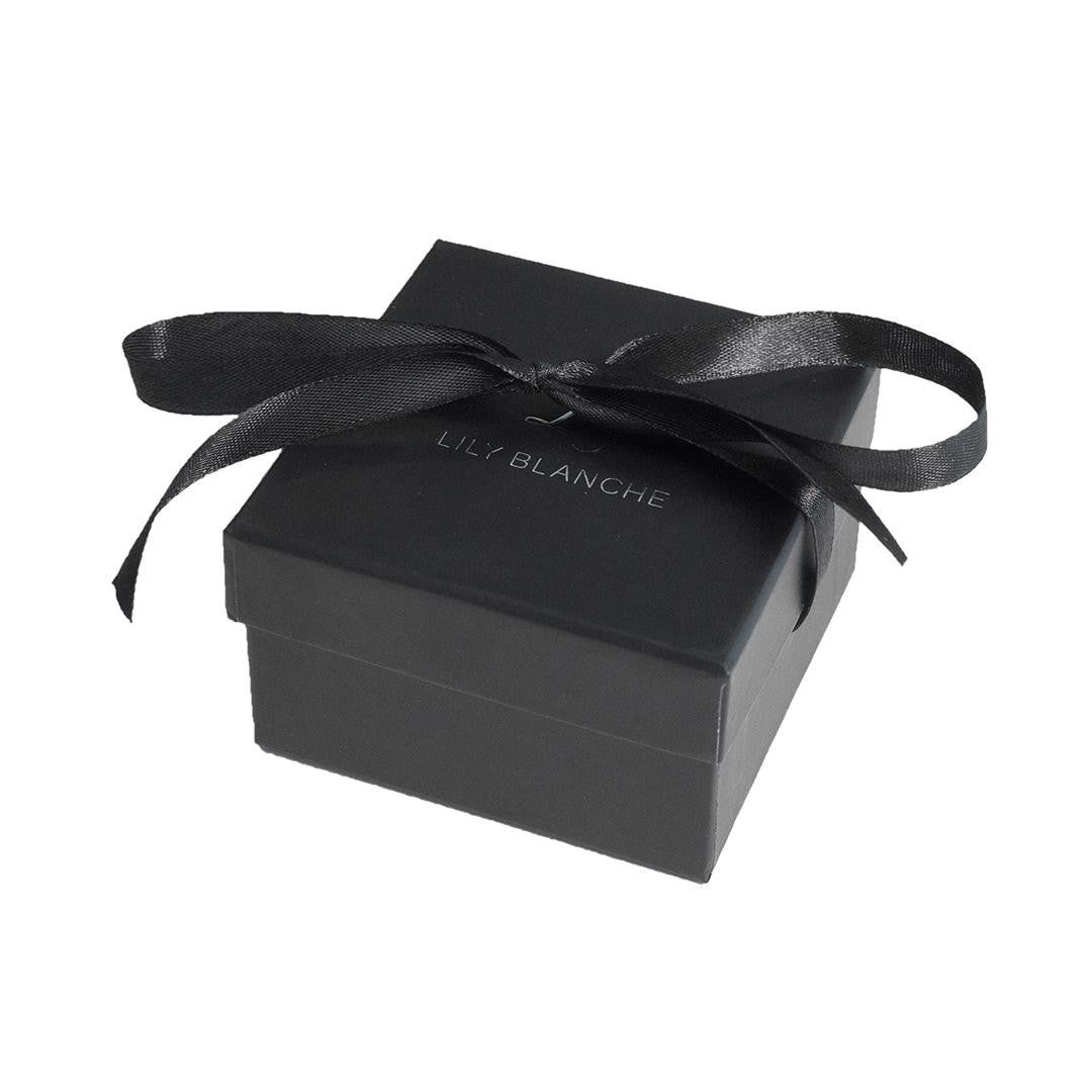 black ribbon-tied Lily Blanche gift box sitting on a vanity table
