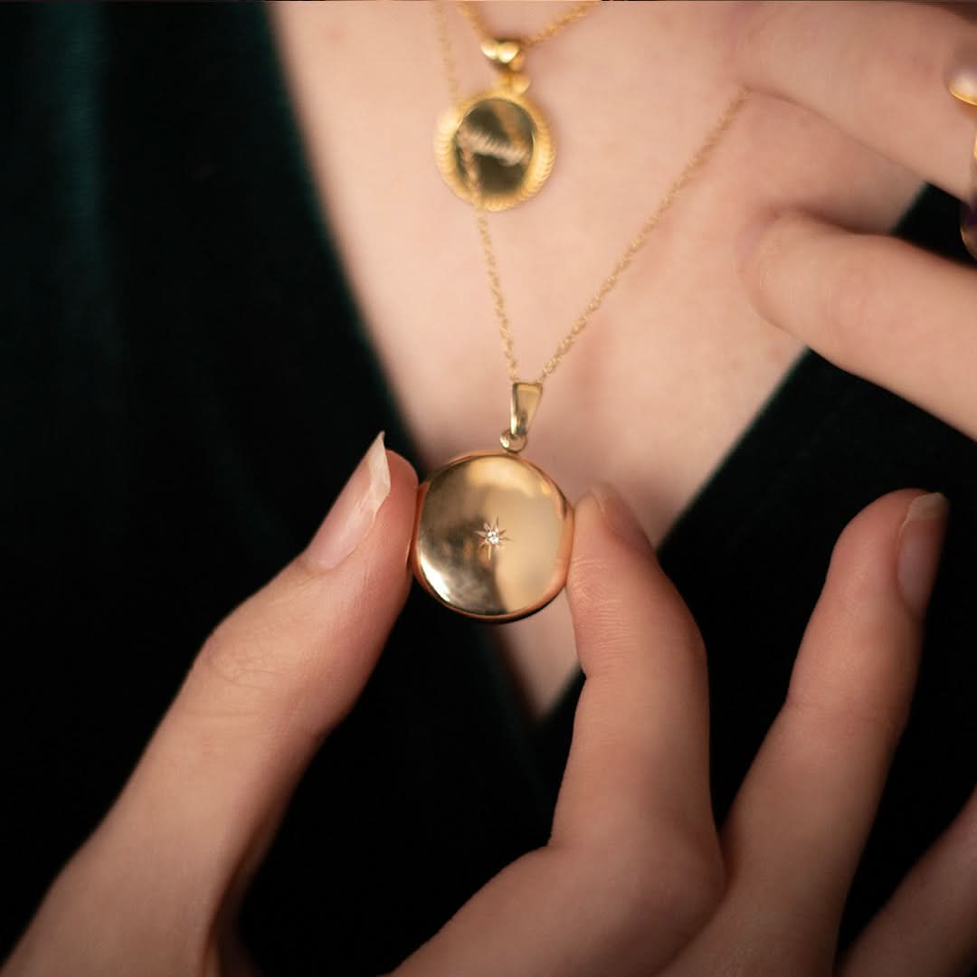 closeup of model wearing diamond round locket in gold