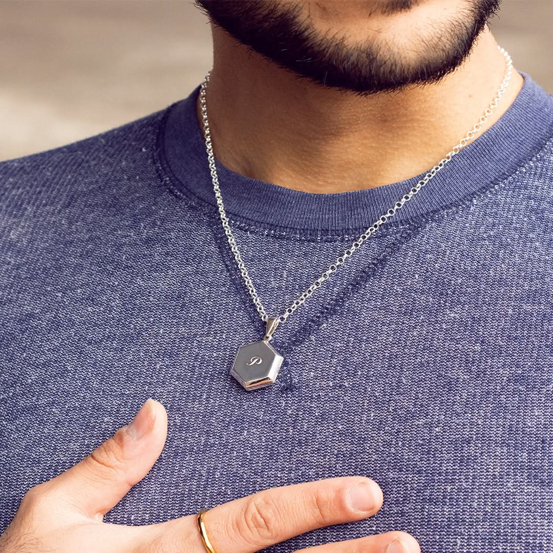 model wearing opened hexagon locket in silver with photos inside